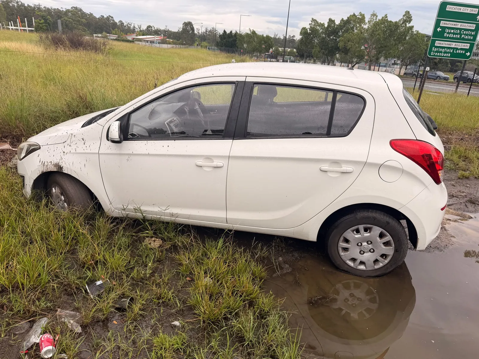 Bogged Hyundai passenger car in saturated ground near Springfield Lakes before TowFast recovery