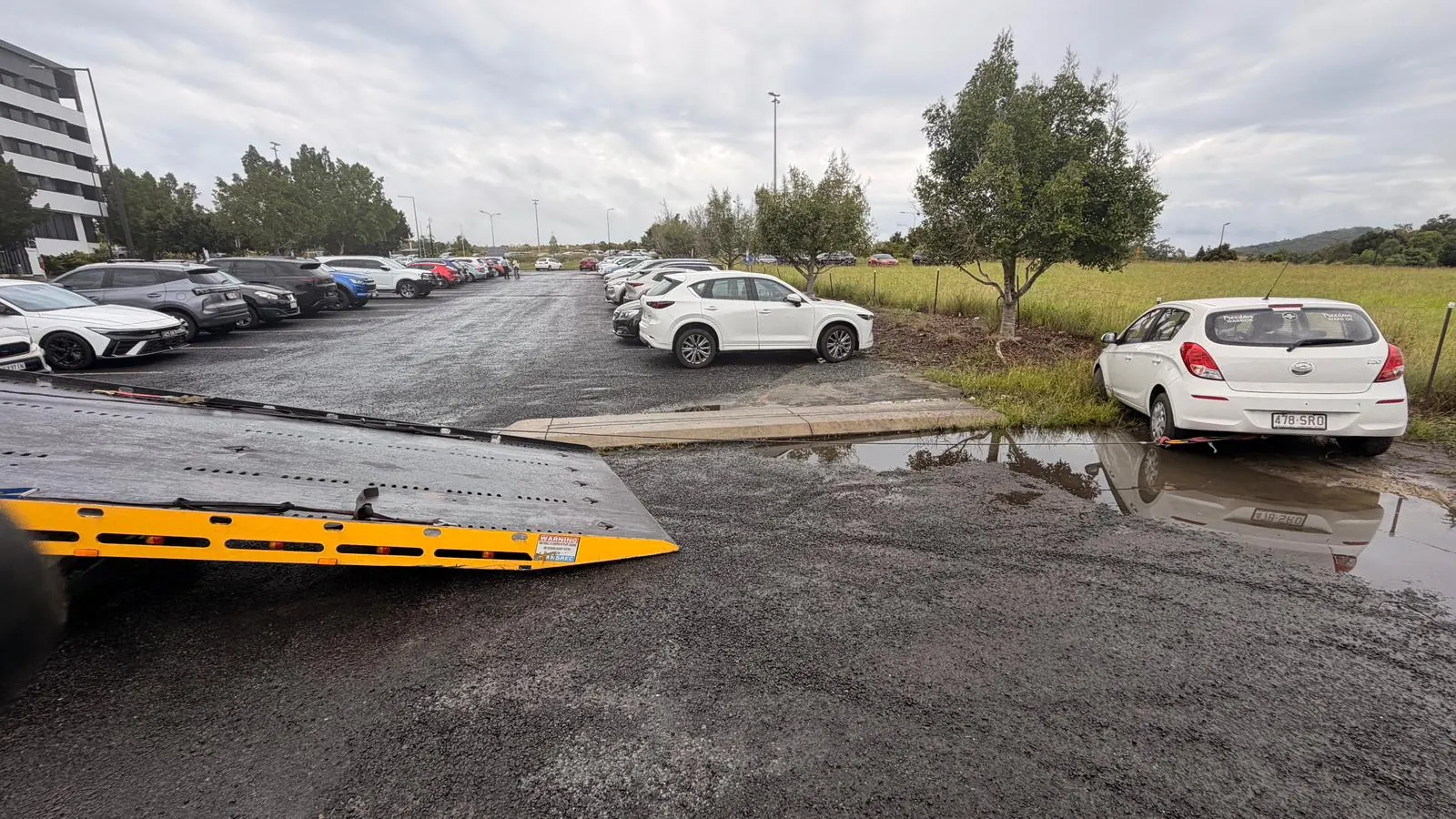 TowFast tilt tray positioned beside a bogged vehicle near Springfield Lakes